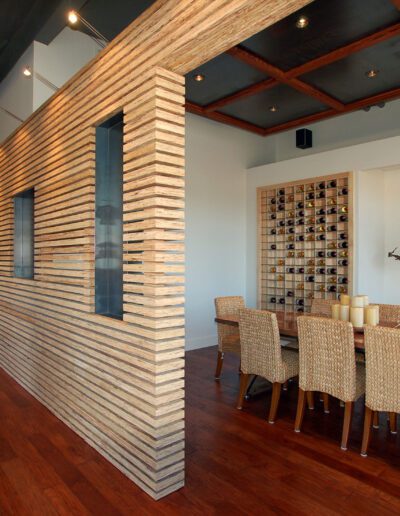 Modern dining room with a textured wooden feature wall and wine storage.